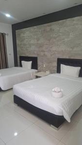 a bedroom with two beds with a hat on it at The one residence in Ban Nong Phak Nam