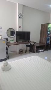 a bedroom with a bed and a desk with a television at The one residence in Ban Nong Phak Nam