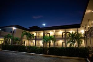 a building with palm trees in front at night at The one residence in Ban Nong Phak Nam