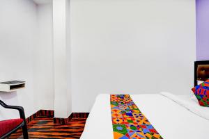 a white bed with a colorful tie on it at FabHotel Triotel Inn in Dhanbād
