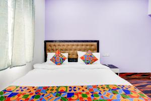 a bedroom with a large bed with a colorful comforter at FabHotel Triotel Inn in Dhanbād