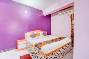 a bedroom with a bed with a purple wall at FabHotel Triotel Inn in Dhanbād +29 photos