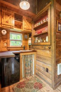 a kitchen with wooden walls and a counter with a sink at The Owl's Perch in Robbinsville