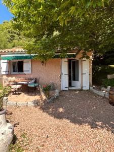 a small house with a table and a patio at Mini villa de charme. in Zonza