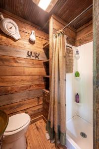 a bathroom with wooden walls and a toilet and a shower at The Owl's Perch in Robbinsville