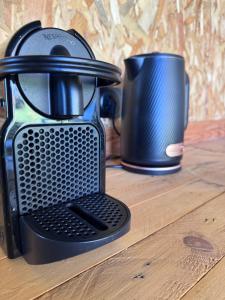 a black coffee maker and a cup on a table at Sunrise Tent in Sageau
