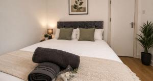 a bedroom with a large white bed with a black headboard at Contractor Workforce Accommodation - 5 Bedrooms Perfect For Work Crews & Groups, WiFi Smart TV's In All Rooms - Parking Sleeps 5-8 Guests in Kettering