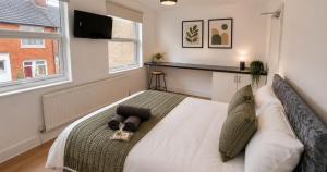 a bedroom with a bed with a television on the wall at Contractor Workforce Accommodation - 5 Bedrooms Perfect For Work Crews & Groups, WiFi Smart TV's In All Rooms - Parking Sleeps 5-8 Guests in Kettering +4 photos