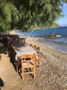 a wooden table and chairs on a beach at Eratous Seaside House in Varnávas