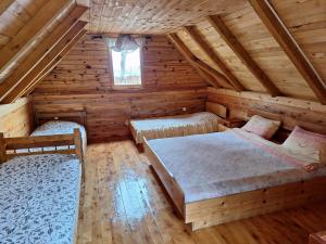 a bedroom with two beds in a log cabin at Kolibe Ćorić in Mojkovac +90 photos