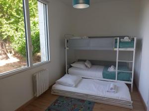 two bunk beds in a room with a window at La troglo aux oiseaux in Montrichard