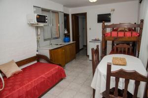 a room with a bed and a table and a kitchen at Apart Hotel Natural del Daymán in Salto +26 photos