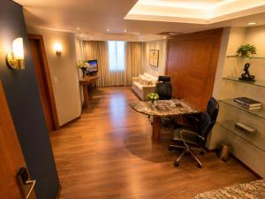 a living room with a table and a couch at Novo Santoni Hotel Guarapuava in Guarapuava +37 photos