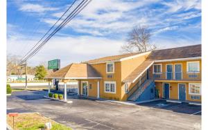 a small yellow building in a parking lot at Sunflower Inn Atlantic City Absecon in Galloway