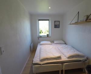 a bed in a room with a window at Top Modern Holiday Home 100 M From The Baltic Sea in Nordborg