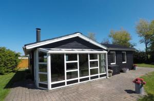 a house with a large screened in porch at Top Modern Holiday Home 100 M From The Baltic Sea in Nordborg +12 photos