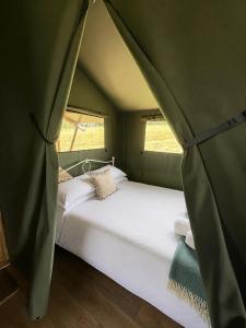 a bedroom with a bed in a tent at Brocklands Farm Glamping in Petersfield