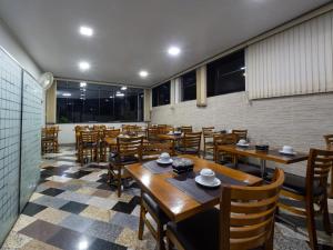 a restaurant with wooden tables and chairs and windows at Hotel Boa Vista by Carlton in Americana +45 photos