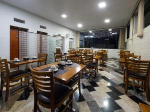 a dining room with wooden tables and chairs at Hotel Boa Vista by Carlton in Americana