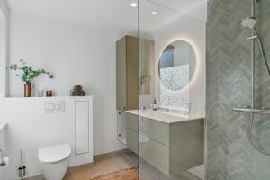 a bathroom with a shower and a toilet and a sink at Newly Renovated And Modern Cottage Near The Beach in Hornbæk +22 photos