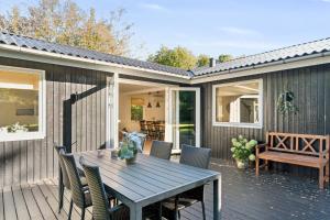 a wooden deck with a table and chairs at Newly Renovated And Modern Cottage Near The Beach in Hornbæk