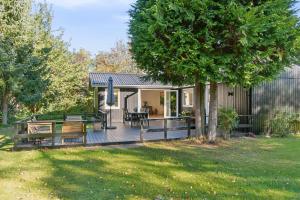 a house with a large deck in a yard at Newly Renovated And Modern Cottage Near The Beach in Hornbæk