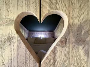 a heart shaped mirror on a wall with a bed at Brocklands Farm Glamping in Petersfield +12 photos