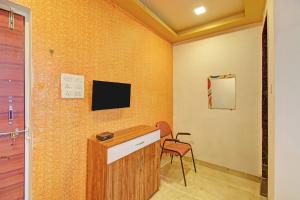 a room with a desk and a tv on a wall at Via Kamal Stay Inn in Alandi