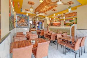a restaurant with wooden tables and chairs and a bar at Via Kamal Stay Inn in Alandi