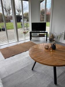 a living room with a table and a television at Summer House Near The Sea And Good Experiences in Børkop
