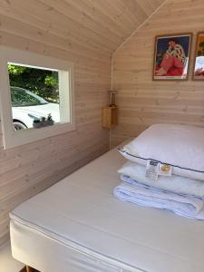 a bed in a wooden room with a window at Summer House Near The Sea And Good Experiences in Børkop