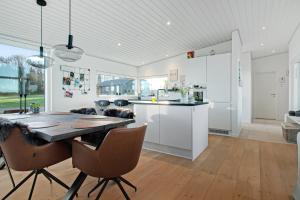 a kitchen and dining room with a table and chairs at New Modern Holiday Home Near The Beach in Aabenraa