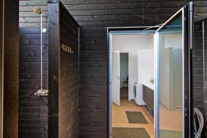 a bathroom with black walls and a glass door at New Modern Holiday Home Near The Beach in Aabenraa +23 photos