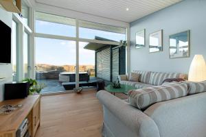 a living room with a couch and a large window at New Modern Holiday Home Near The Beach in Aabenraa