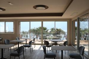 a dining room with tables and chairs and windows at Villa Helena in Limone sul Garda
