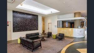 a waiting room with chairs and a table and a chalkboard at Esplanade 88 in Darwin