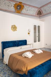 a bedroom with a blue bed with towels on it at B&B Faraglione in Lipari