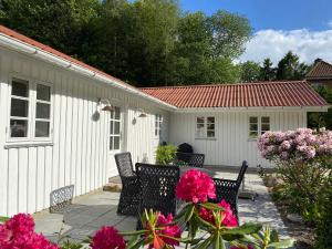 a patio with chairs and flowers in front of a house at Idyllically Situated Wooden House By The Forest in Viborg