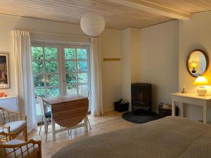 a bedroom with a bed and a table and a window at Idyllically Situated Wooden House By The Forest in Viborg