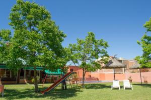 a playground with a slide in a yard at Apart Hotel Natural del Daymán in Salto
