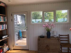 a room with a door and a table with flowers at Nice Summer House With Sea View in Jægerspris