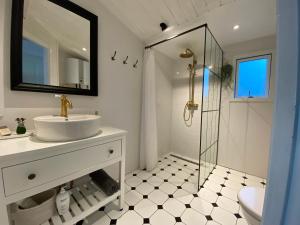 a white bathroom with a sink and a shower at Beautifully Situated Summer House With Sea View in Allinge +30 photos