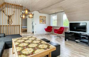 ein Wohnzimmer mit einem Tisch und einem Fernseher in der Unterkunft Schönes Ferienhaus Auf Bornholm Mit Meerblick in Neksø