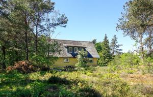 ein gelbes Haus mit blauem Dach auf einem Feld in der Unterkunft Schönes Ferienhaus Auf Bornholm Mit Meerblick in Neksø