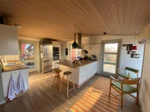 a large kitchen with a counter and chairs in it at Family Friendly Holiday Home In Orø in Holbæk