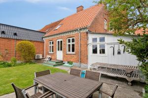 a backyard with a table and chairs and a house at Cozy Holiday Home In Marstal On Ærø in Marstal