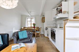 a living room with a table and a kitchen at Holiday Apartment In Peaceful Surroundings in Neksø