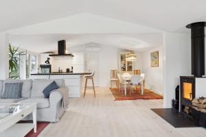 a white living room with a couch and a kitchen at Relaxing Sanctuary In Desirable Area in Hornbæk +13 photos