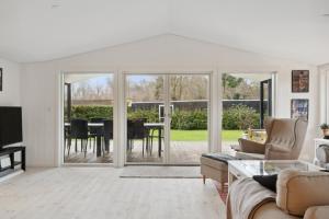 a living room with sliding glass doors and a table at Relaxing Sanctuary In Desirable Area in Hornbæk