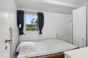 a white bedroom with a bed and a window at Relaxing Sanctuary In Desirable Area in Hornbæk